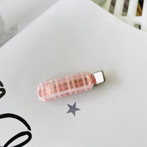 Close-up of pink checkered resin hair clip with durable silver metal duckbill clamp