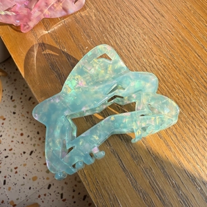 Star-shaped acetate claw clip with iridescent blue shell texture for women's hair