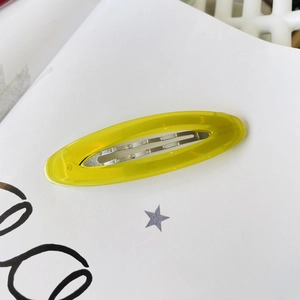 Detail of yellow oval acetate hair clip with Barrette La France engraved lettering