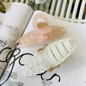 Detail of pink and creamy white bear hair claws on a magazine with a soft aesthetic vibe