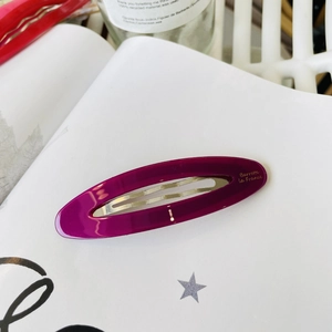 Detail of oval purple acetate hair clip with golden Barrette La France lettering