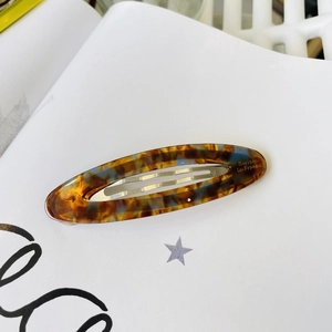 Detail of French vintage oval acetate hair clip with tortoise shell pattern and metal clip