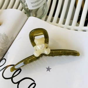 Detail of olive green resin shark hair clip with a cute cream bear and pearl heart