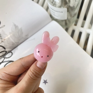 Detail shot of a cute pink resin rabbit hair clip with a bow tie decoration