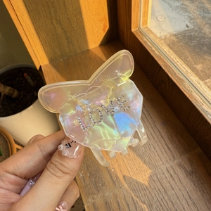 Iridescent butterfly hair claw with LOVE rhinestone letters on a wooden background