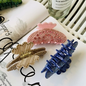 Detailed view of luxury acetate hair claws with full diamond setting in pink and beige
