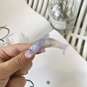 Detailed macro view of a translucent pearlescent purple dolphin-shaped resin hair clip