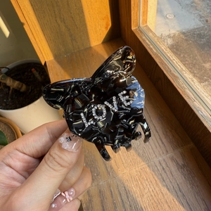 Macro detail of tortoiseshell acetate hair claw clip with rhinestones LOVE lettering