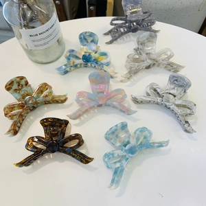 Elegant acetic acid ribbon bow hair claw clips in various marble and tortoiseshell patterns