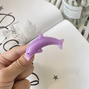 Detail of light purple dolphin hair clip made of smooth translucent resin