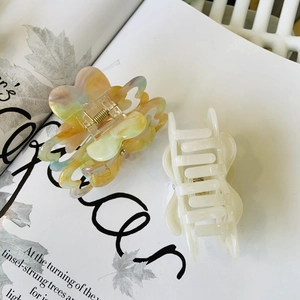 Detail of marble pattern and translucent white petal hair claws on a magazine