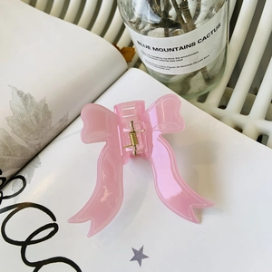 Pince à cheveux élégante avec nœud rose clair, finition brillante et ressort doré chic