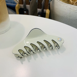 Elegant beige acetate hair claw clip with black trim and sparkling diamond accents