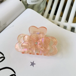 Elegant pink acetate bow hair claw with sparkling rhinestones and pearlescent finish