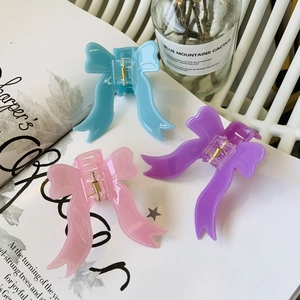 Vue détaillée de trois pinces à cheveux nśud pastel avec rubans élégants et ressorts dorés