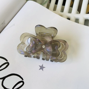 Close-up of butterfly hair claw clip in smoky grey acetate with iridescent pearl finish