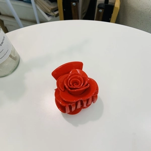 Vue macro d'une pince à cheveux rose 3D rouge avec pétales en résine brillante et dents