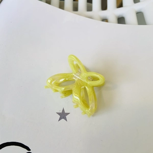Elegante molletta a farfalla in acetato giallo con trama marmorizzata e molla in metallo
