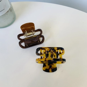 Close-up of large acetate hair claws in brown and tortoiseshell with gold springs