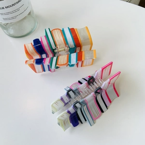 Dettaglio di fermacelli per capelli stile Y2K con un design creativo a forma di libri colorati