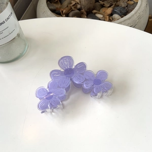 Detail of light purple frosted acrylic flower hair claw with translucent petal texture