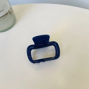 Detailed side view of navy blue rectangular hair claw clip with Creation France gold text