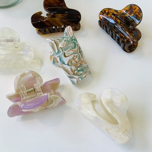 Close-up of assorted acetate hair claws featuring marble and tortoiseshell patterns
