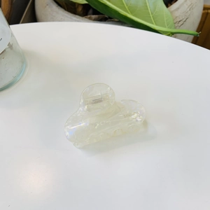 Close-up of iridescent acetate hair claw clip with metallic spring for ponytail styling