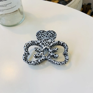 Détail d'une pince à cheveux à nœud avec motif tacheté noir et blanc poli
