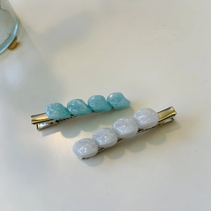 Eleganti fermagli per capelli con motivo marmorizzato blu e bianco su sfondo neutro