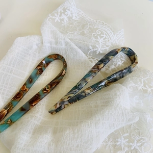 French retro U-shaped acetate hair pins with marble texture on lace fabric background