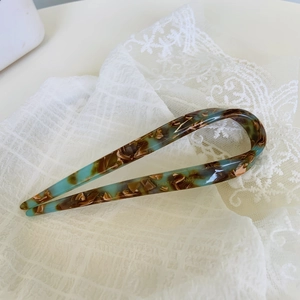 Detail of tortoise shell acetate U-shape hairpin with gold Creation France logo