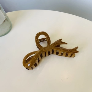 Braune Haarklammer in Schleifenform mit glänzender Holzstruktur für elegantes Haarstyling