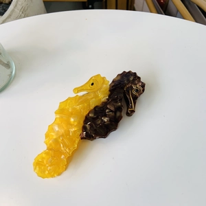 Seahorse-shaped acetate hair claw clip in yellow and tortoiseshell dual-tone design
