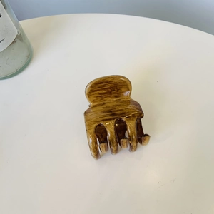 Detail einer großen Haarklammer in Holzmaserung-Optik mit klassischem Schleifen-Design