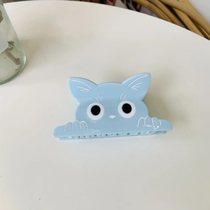 Detailansicht der makaronblauen Katzen-Haarklammer mit süßen Augen auf Weiß
