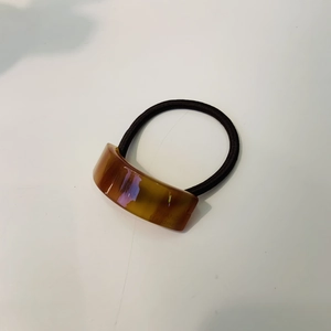 Détail de l'élastique à cheveux en résine ambre fait main avec gravure élégante