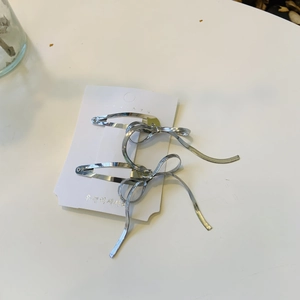 Détail de barrettes à cheveux en forme de nœud argenté avec texture maille serpent