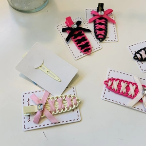 Detail of woven ribbon bow hair clips with central square rhinestone on display cards