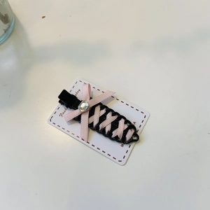 Pink ribbon bow hair clip with lace-up design and sparkling rhinestone on a display card