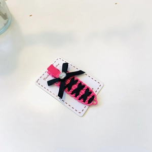 Pink bow hair clip with black ribbon cross weave and rhinestone on jewelry card