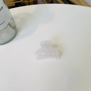 Détail d'une mini pince à cheveux blanc crème translucide pour le coiffage quotidien