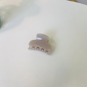 Petite pince à cheveux carrée brillante de couleur moka clair sur un fond blanc épuré