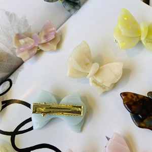 Dettaglio di fermagli per capelli a farfalla in acetato colorato con clip in metallo