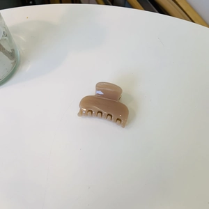 Gros plan d'une petite pince à cheveux carrée rose en résine brillante pour les coiffures