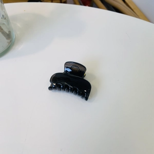 Vue de dessus d'une pince à cheveux carrée noire brillante avec des dents lisses