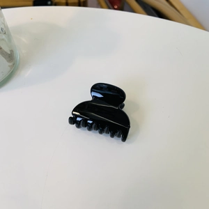 Détail d'une petite pince à cheveux noire brillante pour la coiffure d'été quotidienne