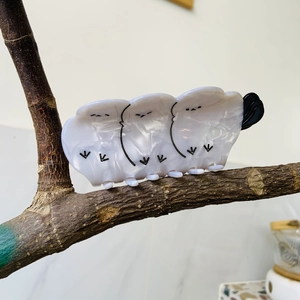 Acetic acid long-tailed tit hair claw clip styled on a natural brown tree branch