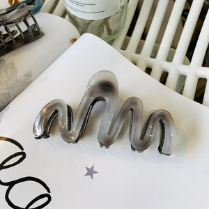 Dettaglio macro della pinza per capelli a onde con trama a inchiostro marmorizzato grigio