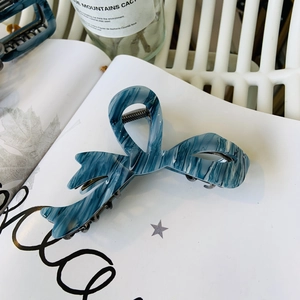 Dettaglio della molletta per capelli a farfalla con motivo a inchiostro marmorizzato blu